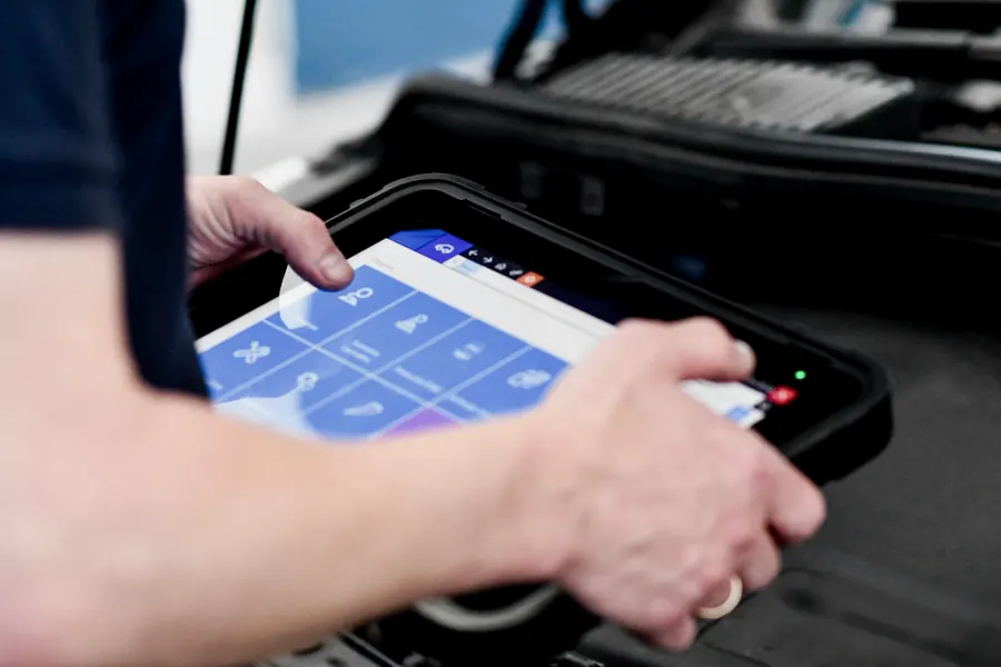 Mechaniker liest mit einem Diagnose-Tablet den Fehlerspeicher aus